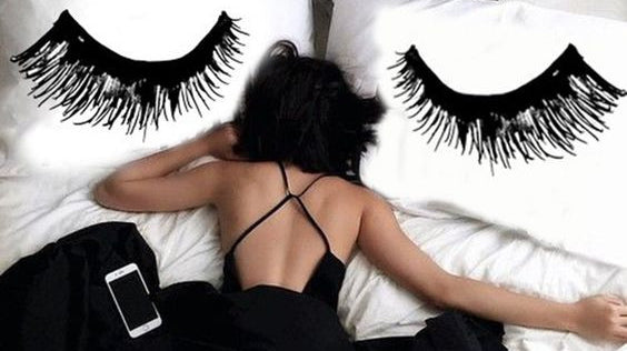girl laying in bed with eyelash extensions