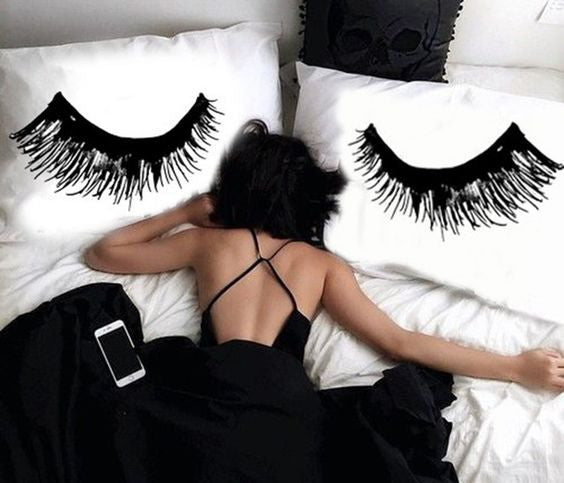 girl laying in bed with eyelash extensions